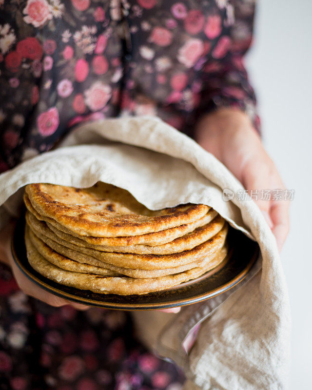 妇女拿着传统的印度面包- Aloo paratha或aalu paratha，土豆填充面包
